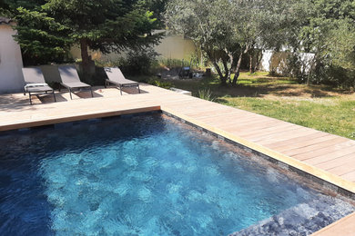 Idées déco pour une piscine méditerranéenne de taille moyenne et rectangle avec une terrasse en bois.