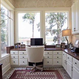 Bild på ett mellanstort vintage hemmabibliotek, med beige väggar, tegelgolv och ett inbyggt skrivbord