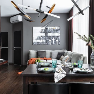 Inspiration för ett mellanstort funkis allrum med öppen planlösning, med ett finrum, grå väggar, mörkt trägolv, en väggmonterad TV och brunt golv