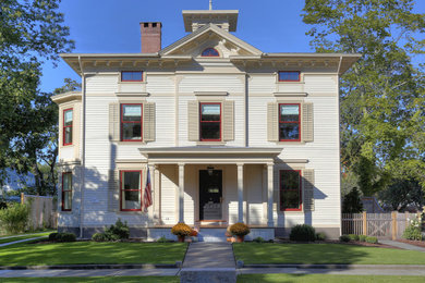 Large ornate beige three-story concrete fiberboard and clapboard house exterior photo in Bridgeport with a hip roof, a shingle roof and a gray roof