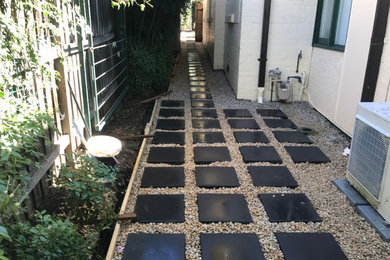 This is an example of a small contemporary side yard partial sun garden in Sydney with with path and concrete pavers.