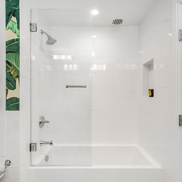 White Soaking Tub with White Tile Backsplash and Built-in Shelving