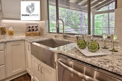 Kitchen pantry - large transitional u-shaped dark wood floor kitchen pantry idea in Other with a farmhouse sink, shaker cabinets, white cabinets, granite countertops, white backsplash, subway tile backsplash, stainless steel appliances and a peninsula