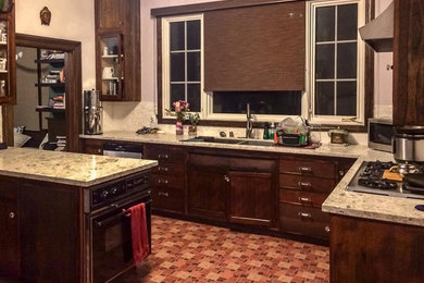 Inspiration for a mid-sized craftsman l-shaped ceramic tile and orange floor eat-in kitchen remodel in San Francisco with shaker cabinets, dark wood cabinets, an island, a double-bowl sink, granite countertops, black appliances and beige countertops