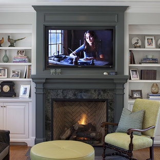 Design ideas for a traditional family room in San Francisco with grey walls, medium hardwood floors, a standard fireplace, a wall-mounted tv and a wood fireplace surround.