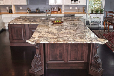 Inspiration for a large timeless l-shaped brown floor eat-in kitchen remodel in Other with an island, granite countertops, an undermount sink, recessed-panel cabinets, white cabinets and stainless steel appliances