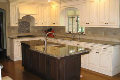 Small elegant l-shaped medium tone wood floor and brown floor enclosed kitchen photo in Other with an island, a drop-in sink, raised-panel cabinets, beige cabinets, granite countertops, beige backsplash, cement tile backsplash and stainless steel appliances