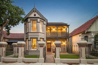 This is an example of a traditional two-storey stucco beige exterior in Sydney with a gable roof.