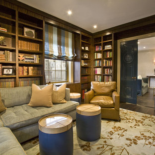 Large modern home office in New York with a library and dark hardwood floors.