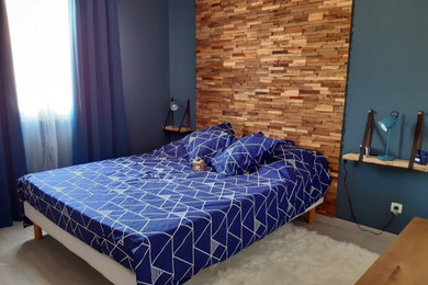 Cette image montre une chambre minimaliste en bois de taille moyenne avec un mur bleu et sol en stratifié.