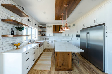 Midcentury u-shaped kitchen/diner in Other with flat-panel cabinets, white cabinets, white splashback, an island, brown floors and white worktops.