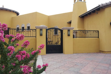 Photo of a large mediterranean full sun side yard concrete paver landscaping in Phoenix for summer.