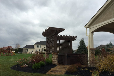 Small trendy backyard stone patio photo in Columbus with a pergola