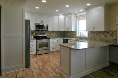 Example of a transitional kitchen design in Other with an undermount sink, white cabinets, granite countertops, ceramic backsplash, stainless steel appliances and a peninsula