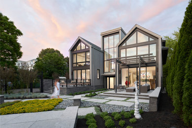 Foto de fachada de casa gris y gris actual grande de tres plantas con revestimiento de madera, tejado a dos aguas y tejado de teja de madera