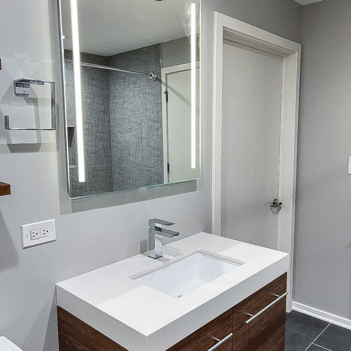Example of a mid-sized minimalist gray tile and porcelain tile porcelain tile, gray floor and single-sink bathroom design in Chicago with flat-panel cabinets, brown cabinets, a two-piece toilet, gray