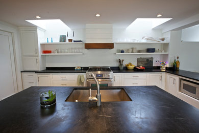 Eat-in kitchen - traditional eat-in kitchen idea in Burlington with an undermount sink, flat-panel cabinets and stainless steel appliances