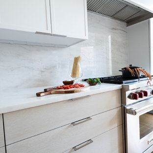 Idée de décoration pour une arrière-cuisine linéaire vintage de taille moyenne avec un évier encastré, un placard à porte shaker, des portes de placard blanches, un plan de travail en marbre, une crédence blanche, une crédence en marbre, un électroménager en acier inoxydable, un sol en bois clair, un îlot central, un sol marron et un plan de travail blanc.