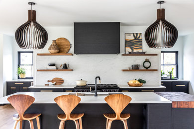 Example of a trendy kitchen design in Portland Maine with an undermount sink, white backsplash, stone slab backsplash, an island and white countertops