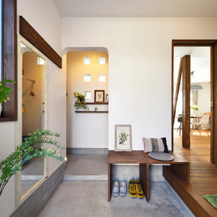 他の地域の北欧スタイルのおしゃれな玄関 (白い壁、コンクリートの床、グレーの床) の写真