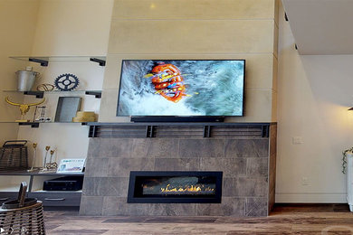 Example of a large minimalist open concept medium tone wood floor and brown floor living room design in Other with beige walls, a ribbon fireplace, a tile fireplace and a wall-mounted tv