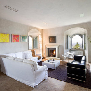 Foto de salón cerrado, mediterráneo, con paredes blancas, suelo de ladrillo, chimenea tradicional y marco de chimenea de piedra