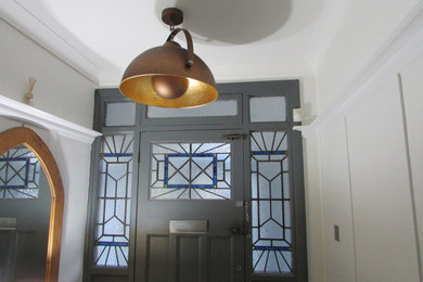 Inspiration for a contemporary medium tone wood floor hallway remodel in London with white walls