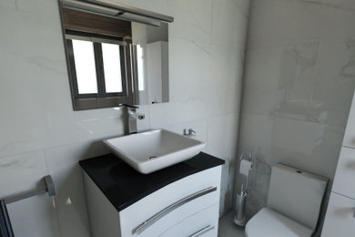 Imagen de cuarto de baño único y flotante minimalista pequeño con puertas de armario de madera clara, ducha a ras de suelo, suelo de mármol, aseo y ducha, suelo blanco, ducha con puerta corredera, encimeras negras y cuarto de baño