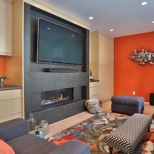 This is an example of a medium sized contemporary walk-out basement in Vancouver with orange walls, a ribbon fireplace and a stone fireplace surround.