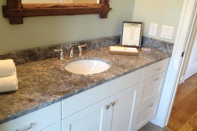 This is an example of a mid-sized traditional 3/4 bathroom in Richmond with recessed-panel cabinets, white cabinets, green walls, ceramic floors, a wall-mount sink and granite benchtops.