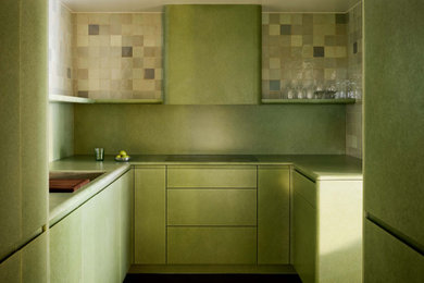 Example of an eclectic u-shaped kitchen design in San Francisco with an undermount sink, flat-panel cabinets, green cabinets, green backsplash, paneled appliances and green countertops