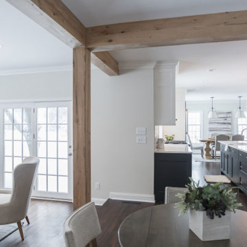 Antique White Oak Box Beams Framing a Modern Dining Room to Kitchen Transition