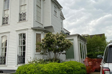 Modelo de fachada de casa blanca clásica de tamaño medio de dos plantas con teja