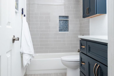 Bathroom - mid-sized transitional 3/4 gray tile and porcelain tile porcelain tile, gray floor and single-sink bathroom idea in Denver with recessed-panel cabinets, blue cabinets, a one-piece toilet, white walls, an undermount sink, quartzite countertops, white countertops and a built-in vanity