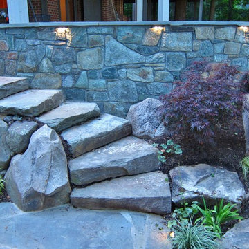 NIGHT VIEW OF STONE SLAB STEPS FITTED INTO CURVING WALL