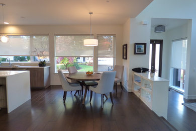 This is an example of a mid-sized contemporary kitchen/dining combo in Portland with dark hardwood floors, brown floor, white walls and no fireplace.