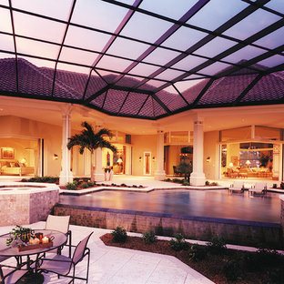 Photo of an expansive transitional backyard patio in Miami with a water feature, natural stone pavers and a roof extension.