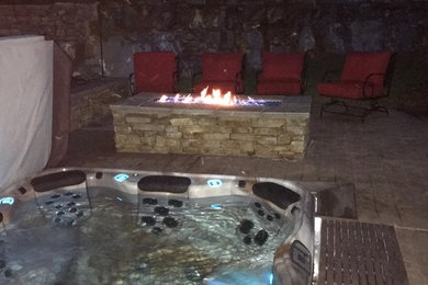 Mid-sized elegant backyard brick and rectangular aboveground hot tub photo in Other