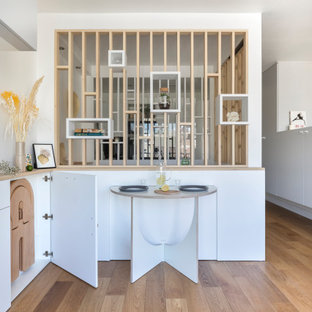 Inspiration pour une salle à manger ouverte sur le salon design avec un sol en contreplaqué.