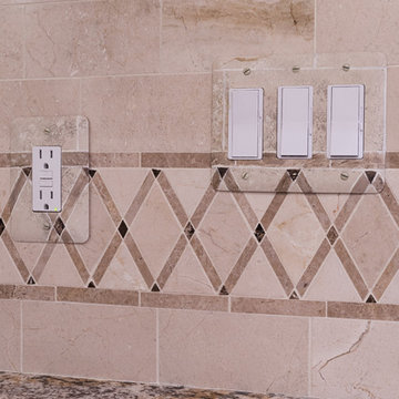 La Crema Marfil Marble field tile with accent tiles coordinate with the granite.