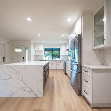 Modern White Shaker Kitchen with Navy Blue Island and Waterfall Quartz Counterto