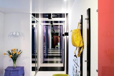 Idee per un piccolo ingresso o corridoio eclettico con pareti bianche, pavimento in gres porcellanato e pavimento multicolore