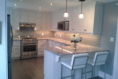 Kitchen - contemporary dark wood floor kitchen idea in Toronto with an undermount sink, shaker cabinets, white cabinets, granite countertops, gray backsplash, ceramic backsplash and stainless steel appliances