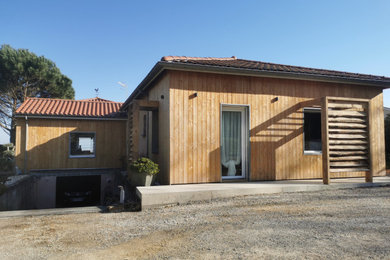 Idées déco pour une façade de maison beige éclectique en bois de plain-pied avec un toit à quatre pans, un toit en tuile et un toit rouge.