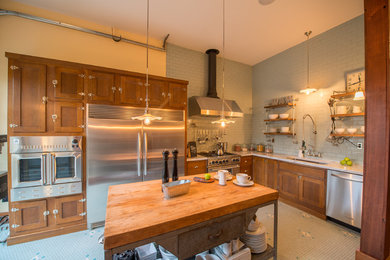 Kitchen - large country l-shaped ceramic tile kitchen idea in Seattle with an undermount sink, shaker cabinets, medium tone wood cabinets, marble countertops, blue backsplash, subway tile backsplash, stainless steel appliances and an island