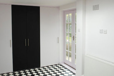 Ejemplo de recibidores y pasillos tradicionales de tamaño medio con paredes blancas, suelo vinílico, suelo negro, casetón y iluminación