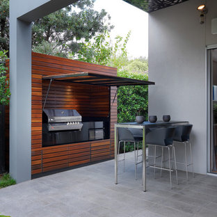 メルボルンの大きいコンテンポラリースタイルのおしゃれな裏庭のテラス (アウトドアキッチン、タイル敷き、張り出し屋根) の写真