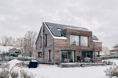 Foto de fachada de casa negra de tamaño medio con revestimiento de madera, tejado a dos aguas y tejado de teja de barro