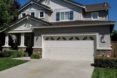 This is an example of a large modern two-storey stucco grey house exterior in Sacramento with a tile roof.
