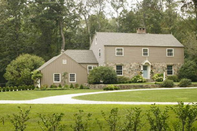 Modelo de fachada de casa verde clásica grande de tres plantas con revestimiento de piedra y tejado a dos aguas